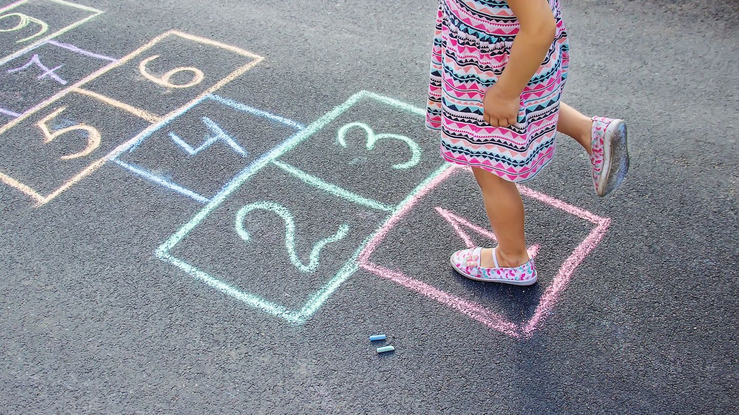 Enfant joue à la marelle dans la cour de récréation