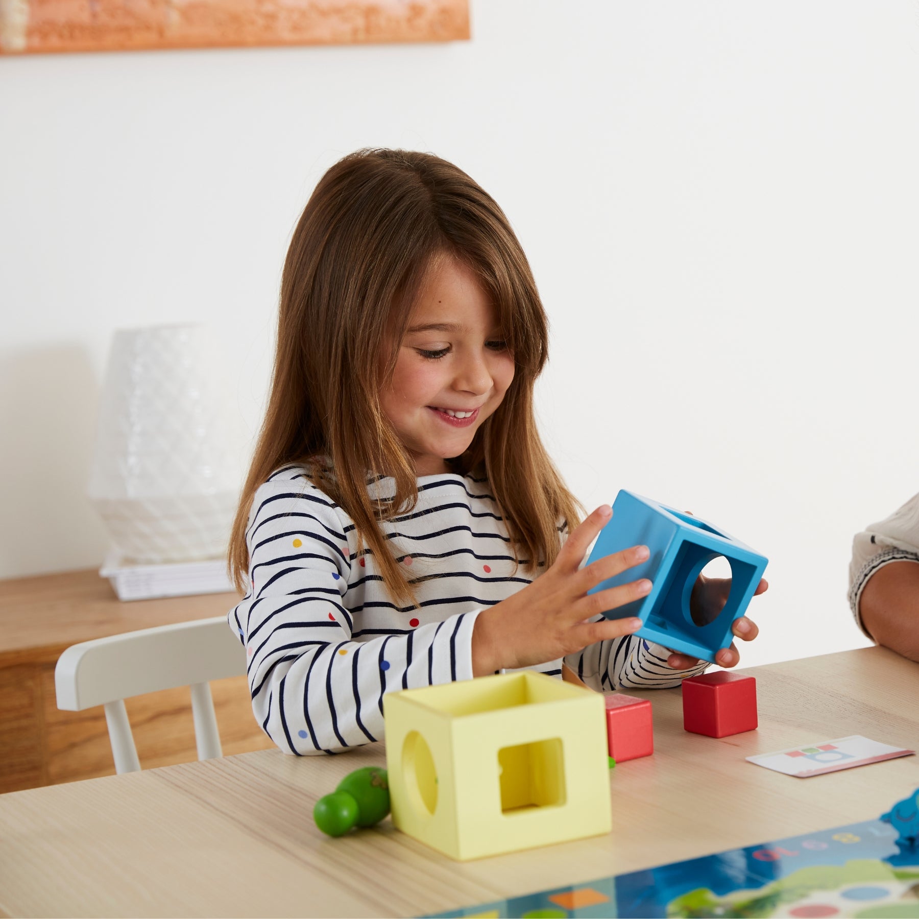 Petite fille sourit avec les cubes en bois
