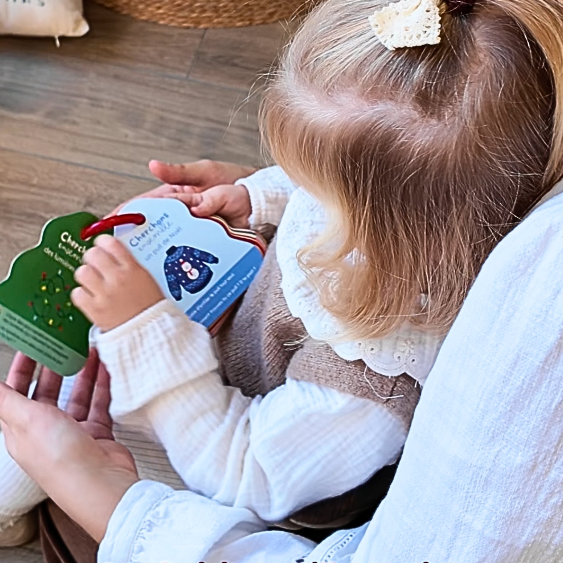 Une maman et sa fille jouent a cherchons ensemble dans un decor de Noel