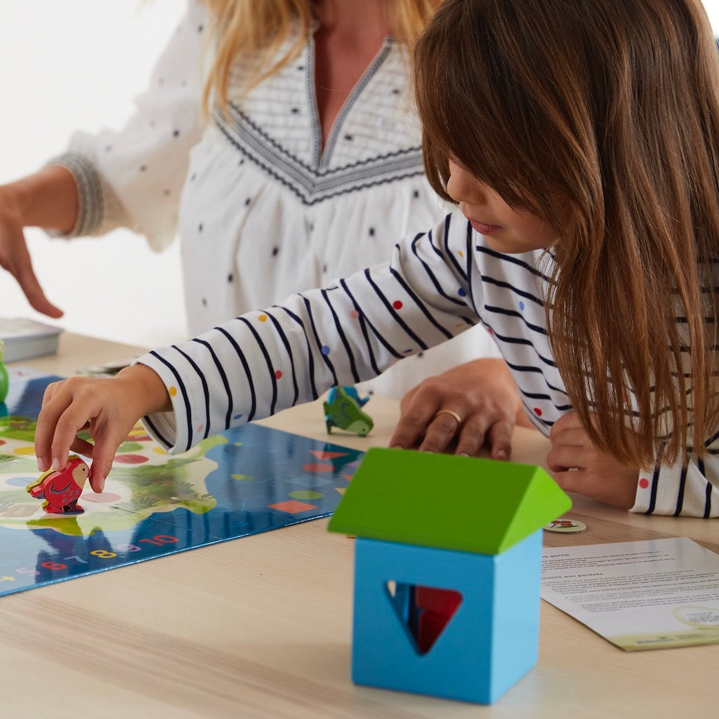 Petite fille avec pions en bois Kakapo sur plateau de jeu Kidsmart